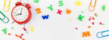 Beyaz masa arka plan kopya alanı, çerçeve, metin veya tasarım şablonu ile üzerinde uzun geniş afiş geri okul kavramı çalar saat, renk okul ve ofis malzemeleri