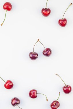 Minimal tarzda beyaz arka plan üzerinde izole kopya alanı ile taze olgun kiraz desen düzeninin yaratıcı üstten görünüm. Yaz eğlenceli ve sağlıklı beslenme kavramı. Metin veya gıda tasarımınız için şablon