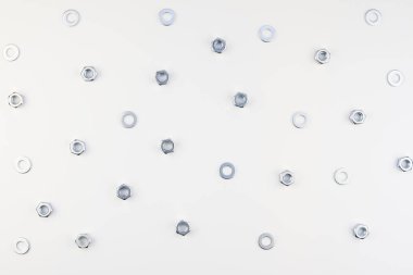 Yaratıcı düz beyaz arka plan üzerinde metal fındık yatıyordu. Onarım veya iyileştirme üstten görünüm kavramı desenli.