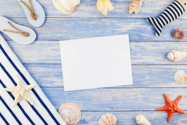 Yaratıcı düz yaz seyahat tatil kavramı yatıyordu. Deniz kabuklarını ve deniz yıldızı kopya alanı rustik tarzı çerçeve şablonu metin pastel mavi ahşap plakalar zemin üzerine üstten görünüm havlu Flip floplar