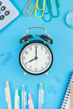 Yaratıcı düz yatıyordu üstten görünüm geri okul kavramı çalar saat, renk okul ve ofis malzemeleri parlak turkuaz kağıt tablo çerçeve arka plan kopya alanı, metin veya tasarım şablonu ile