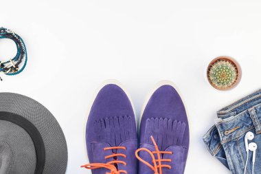 Düz beyaz arka plan kopya alanı ile kulaklıktan süet ayakkabı, kot, gri şapka, kaktüs ve akıllı telefon yatırın. Kadın rahat kıyafet havai görünümü. Trendy hipster bak üstten görünüm