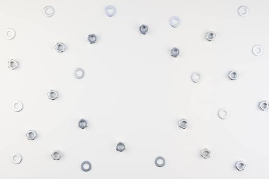 Yaratıcı düz metal fındıklar beyaz arka planda fotokopi alanı ile. Üst görünüm çerçeve şablonunu onar veya geliştir.