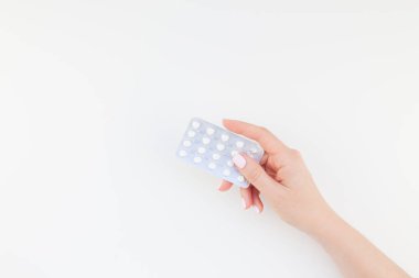 Kadın el ile kopya alanı ile beyaz arka plan üzerinde izole blister hapları holding pastel manikür Lehçe. Kadınsı güzellik blog sosyal medya için şablon. Kadın sağlık kavramı