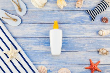 Yaratıcı düz yaz seyahat tatil kavramı yatıyordu. Deniz kabuğu denizyıldızı pastel mavi ahşap plakalar arka plan kopya alanı mockup şablon metin ile üstten görünüm plaj havlusu güneş kremi şişe Flip floplar