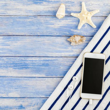 Kare yaratıcı düz yaz seyahat tatil kavramı yatıyordu. Plaj havlusu smartphone deniz kabuğu denizyıldızı üstten görünüm Kopyala yer mockup template metin için pastel mavi ahşap plakalar zemin üzerine