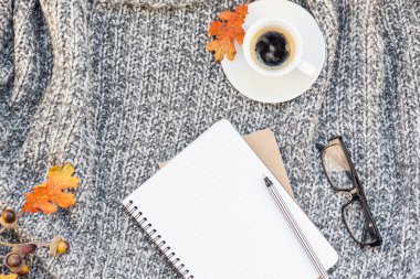 Yaratıcı sonbahar düz ek yükü üstten görünüm şık ev çalışma alanı defter kahve fincanı sıcak gri örgü ekose arka plan kopya alanı ile yatıyordu. Sonbahar sezonu şablon kadınsı blog sosyal medya için