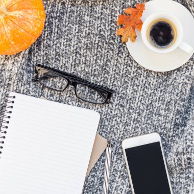 Yaratıcı bir şekilde sonbahar düz ek yükü üstten görünüm şık ev çalışma alanı smartphone defter kahve fincanı sıcak gri örgü ekose arka plan kopya alanı yatıyordu. Sonbahar sezonu şablon kadınsı blog sosyal medya