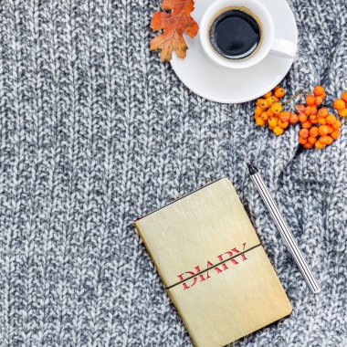 Yaratıcı bir şekilde sonbahar düz ek yükü üstten görünüm şık ev çalışma alanı defter kahve fincanı sıcak gri örgü ekose arka plan kopya alanı ile yatıyordu. Sonbahar sezonu şablon kadınsı blog sosyal medya için