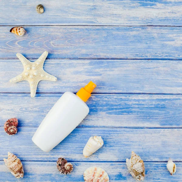 Yaratıcı düz yatıyordu kavramı yaz seyahat tatil kare. Pastel mavi ahşap plakalar arka plan kopya alanı rustik tarzı çerçeve şablonu metin üzerinde güneş kremi şişe mockup kabukları ve denizyıldızı üstten görünüm