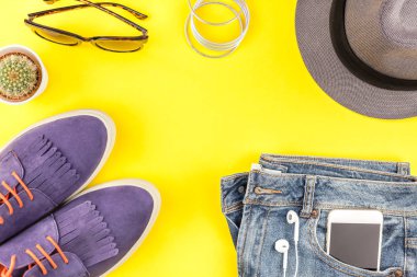 Düz Süet ayakkabı, kot, kalın sarı Kağıt arka plan gri şapka, kaktüs ve akıllı telefon kulaklık kopya alanı ile yatıyordu. Kadın rahat kıyafet havai görünümü. Trendy hipster bak üstten görünüm