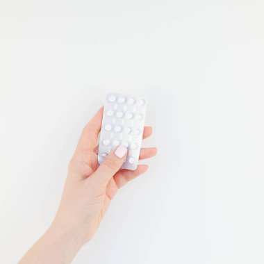 Kadın el ile kopya alanı ile beyaz arka plan üzerinde izole blister hapları holding pastel manikür Lehçe. Kadınsı güzellik blog sosyal medya kare şablonu. Kadın sağlık kavramı