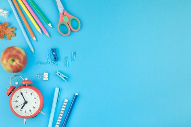 Yaratıcı düz yatıyordu üstten görünüm geri okul kavramı çalar saat, renk okul ve ofis malzemeleri parlak turkuaz kağıt tablo çerçeve arka plan kopya alanı, metin veya tasarım şablonu ile