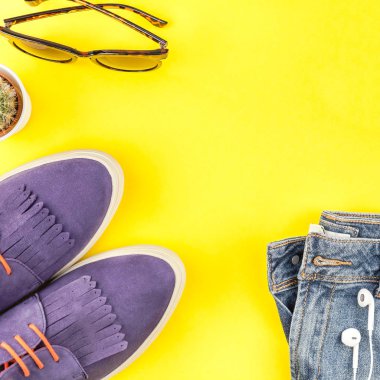Düz Süet ayakkabı, kot, kaktüs ve akıllı telefon kulaklık kalın sarı Kağıt arka plan üzerinde kopya alanı ile yatıyordu. Kadın rahat kıyafet havai görünümü. Kare hipster bak üstten görünüm