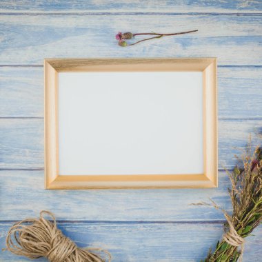 Üstten görünüm çim arka plan ile Kuru çiçek altın çerçeve sahte ile mavi tonda ahşap masa üzerinde kare ve rustik tarzı, metin için şablon alanı Kopyala