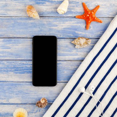 Kare yaratıcı düz yaz seyahat tatil kavramı yatıyordu. Plaj havlusu smartphone deniz kabuğu denizyıldızı üstten görünüm Kopyala yer mockup template metin için pastel mavi ahşap plakalar zemin üzerine