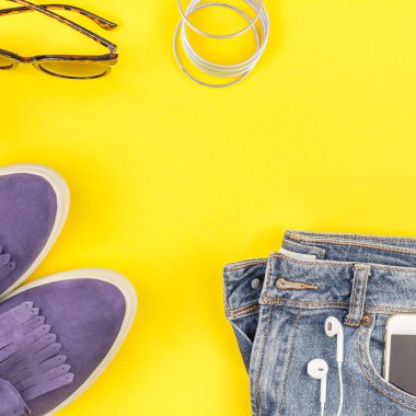 Düz Süet ayakkabı, kot, kalın sarı Kağıt arka plan gri şapka, kaktüs ve akıllı telefon kulaklık kopya alanı ile yatıyordu. Kadın rahat kıyafet havai görünümü. Kare hipster bak üstten görünüm