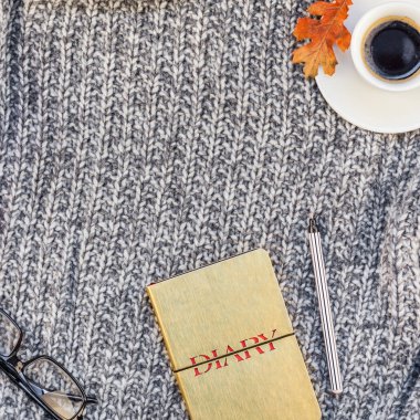 Yaratıcı bir şekilde sonbahar düz ek yükü üstten görünüm şık ev çalışma alanı defter kahve fincanı sıcak gri örgü ekose arka plan kopya alanı ile yatıyordu. Sonbahar sezonu şablon kadınsı blog sosyal medya için