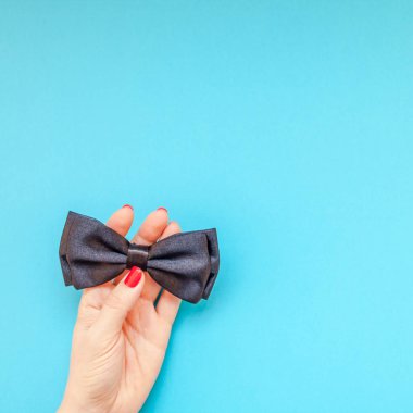 Yaratıcı kare flatlay üstten görünüm retro siyah papyon kadın eller turkuaz Kağıt arka plan kopya alanı. Erkek Sağlığı Farkındalık ay gün erkeklik kavramı blog sosyal medya babalar