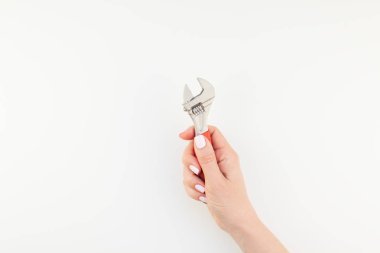 Kadın el minimalizm tarzı beyaz arka plan üzerinde izole kopya alanı ile somun anahtarı tutan pastel manikür Lehçe ile yaratıcı görüntü. Onarım veya iyileştirme feminizm kavramı