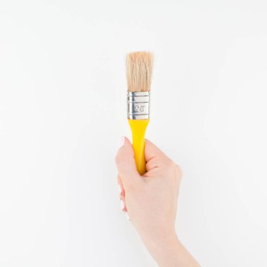 Kare görüntü yeni boya fırçası ile minimalizm tarzı beyaz arka plan üzerinde izole kopya yer tutan kadın el. Kadınsı blog, sosyal medya için şablon. Onarım veya iyileştirme kavramı