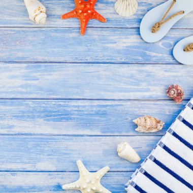 Yaratıcı düz kavramı yaz seyahat tatil yatıyordu. Kabukları ve deniz yıldızı kopya alanı rustik tarzı kare çerçeve şablonu metin pastel mavi ahşap plakalar zemin üzerine üstten görünüm havlu Flip floplar