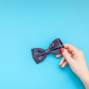 Yaratıcı kare flatlay üstten görünüm retro siyah papyon kadın eller turkuaz Kağıt arka plan kopya alanı. Erkek Sağlığı Farkındalık ay gün erkeklik kavramı blog sosyal medya babalar