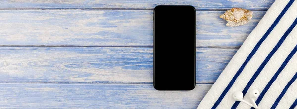 Uzun geniş düz yatıyordu yaz seyahat tatil kavramı banner. Plaj havlusu smartphone deniz kabuğu denizyıldızı üstten görünüm Kopyala yer mockup template metin için pastel mavi ahşap plakalar zemin üzerine