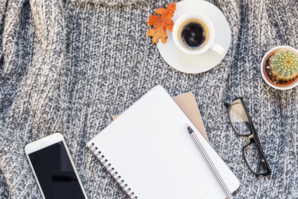 創造的な秋フラット スマート フォン ノート コーヒー カップ居心地の良い背景に灰色ニット チェック柄コピー スペースとオーバーヘッド平面図のスタイリッシュな家のワークスペースが横たわっていた 女性ブログ ソーシャル — ストック写真