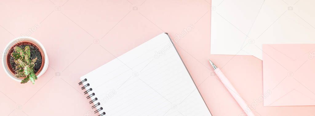 Long wide banner of workspace desk styled design office supplies and cactuses succulents with copy space millennial pink color paper background minimal style. Template for feminine blog social media