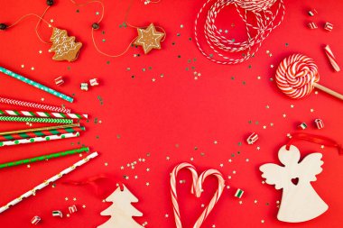 Yeni yıl veya Noel dekorasyon düz üstten görünüm Xmas tatil kutlaması el yapımı dekor Ahşap oyuncaklar tatlılar altın yıldız kırmızı Kağıt arka plan üzerinde parıldayan yatıyordu. Şablon tasarımınızın tebrik kartı için çerçeve