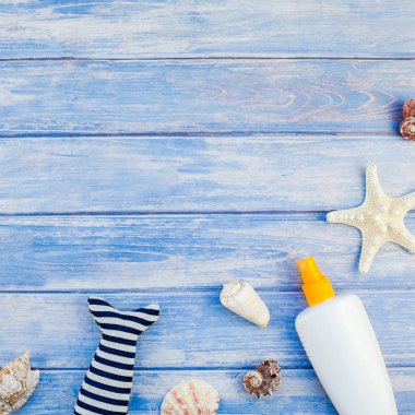 Yaratıcı düz yatıyordu kavramı yaz seyahat tatil kare. Pastel mavi ahşap plakalar arka plan kopya alanı rustik tarzı çerçeve şablonu metin üzerinde güneş kremi şişe mockup kabukları ve denizyıldızı üstten görünüm