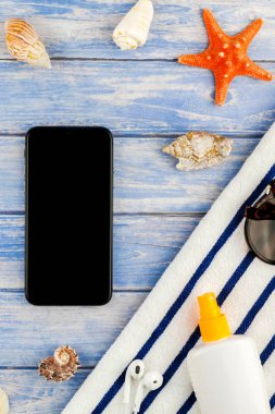 Yaratıcı düz yaz seyahat tatil kavramı yatıyordu. Plaj havlusu smartphone deniz kabuğu denizyıldızı üstten görünüm Kopyala yer mockup template metin için pastel mavi ahşap plakalar zemin üzerine