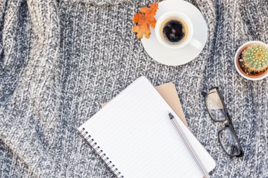 Yaratıcı sonbahar düz ek yükü üstten görünüm şık ev çalışma alanı defter kahve fincanı sıcak gri örgü ekose arka plan kopya alanı ile yatıyordu. Sonbahar sezonu şablon kadınsı blog sosyal medya için
