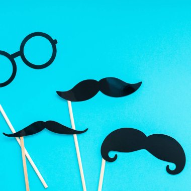 Yaratıcı kare flatlay ek yükü üstten görünüm retro siyah kağıt fotoğraf stand sahne bıyıkları turkuaz arka plan kopya alanı. Erkek Sağlığı Farkındalık ay gün erkeklik kavramı blog sosyal medya babalar