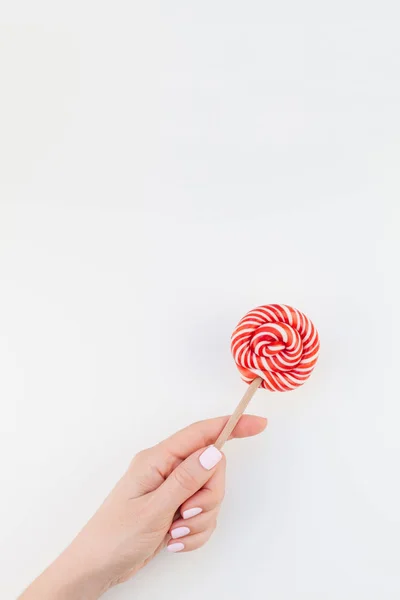 Mão Mulher Com Manicure Pastel Polonês Segurando Pirulito Girando Vermelho — Fotografia de Stock