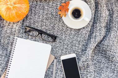 Yaratıcı sonbahar düz ek yükü üstten görünüm şık ev çalışma alanı smartphone defter kahve Kupası rahat gri örgü ekose arka plan kopya alanı ile yatıyordu. Sonbahar sezonu şablon kadınsı blog sosyal medya için