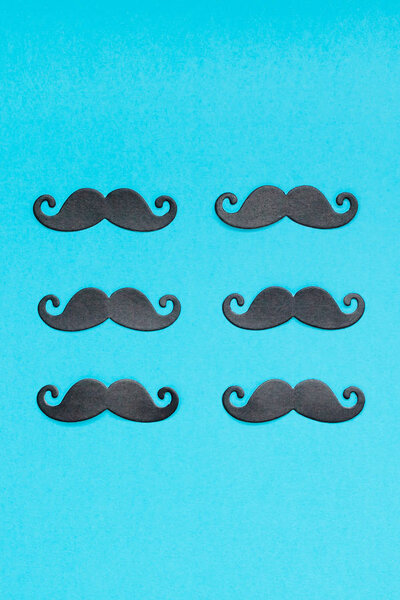 Creative flatlay overhead top view retro stylish black paper photo booth props moustaches turquoise background copy space. Men health awareness month fathers day masculinity concept blog social media