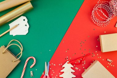 Yeni yıl veya Noel DIY düz üstten görünüm Xmas tatil kutlama el yapımı Hediyelik kutu kırmızı yeşil Kağıt arka plan üzerinde yatıyordu hazırlık sunar. Şablon mockup tebrik kartı veya metin tasarımınızı 2019