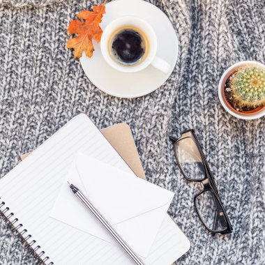 Yaratıcı bir şekilde sonbahar düz ek yükü üstten görünüm şık ev çalışma alanı defter kahve fincanı sıcak gri örgü ekose arka plan kopya alanı ile yatıyordu. Sonbahar sezonu şablon kadınsı blog sosyal medya için