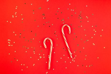 Yeni yıl veya Noel dekorasyon düz üstten görünüm Xmas tatil kutlama el yapımı dekor tatlılar altın yıldız parlak kırmızı Kağıt arka plan üzerinde yatıyordu. Şablon tasarımınızın tebrik kartı için çerçeve