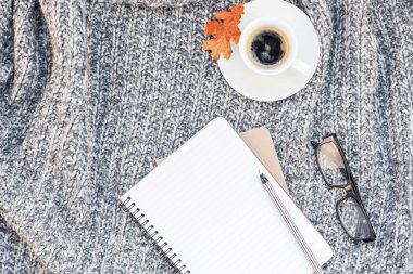 Yaratıcı sonbahar düz ek yükü üstten görünüm şık ev çalışma alanı defter kahve fincanı sıcak gri örgü ekose arka plan kopya alanı ile yatıyordu. Sonbahar sezonu şablon kadınsı blog sosyal medya için