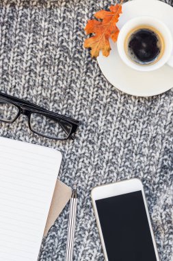 Yaratıcı sonbahar düz ek yükü üstten görünüm şık ev çalışma alanı smartphone defter kahve Kupası rahat gri örgü ekose arka plan kopya alanı ile yatıyordu. Sonbahar sezonu şablon kadınsı blog sosyal medya için