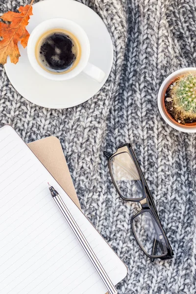 Yaratıcı sonbahar düz ek yükü üstten görünüm şık ev çalışma alanı defter kahve fincanı sıcak gri örgü ekose arka plan kopya alanı ile yatıyordu. Sonbahar sezonu şablon kadınsı blog sosyal medya için