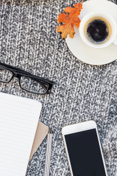 Yaratıcı sonbahar düz ek yükü üstten görünüm şık ev çalışma alanı smartphone defter kahve Kupası rahat gri örgü ekose arka plan kopya alanı ile yatıyordu. Sonbahar sezonu şablon kadınsı blog sosyal medya için