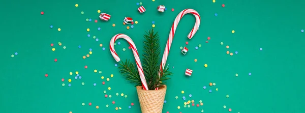New Year Christmas Xmas holiday party celebration waffle cone candy canes fir tree branch copy space green color paper wide long banner. Template greeting card 2019