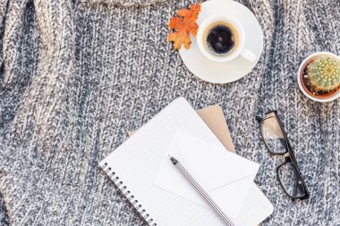 Yaratıcı sonbahar düz ek yükü üstten görünüm şık ev çalışma alanı defter kahve fincanı sıcak gri örgü ekose arka plan kopya alanı ile yatıyordu. Sonbahar sezonu şablon kadınsı blog sosyal medya için