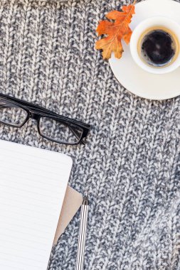 Yaratıcı sonbahar düz ek yükü üstten görünüm şık ev çalışma alanı defter kahve fincanı sıcak gri örgü ekose arka plan kopya alanı ile yatıyordu. Sonbahar sezonu şablon kadınsı blog sosyal medya için