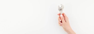 Kadın el minimalizm tarzı beyaz arka plan üzerinde izole kopya alanı ile somun anahtarı tutan pastel manikür Lehçe ile yaratıcı geniş uzun afiş. Onarım veya iyileştirme feminizm kavramı