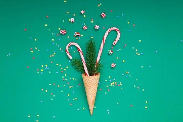 New Year Christmas Xmas holiday party celebration waffle cone candy canes fir tree branch copy space green color paper background. Template greeting card 2019